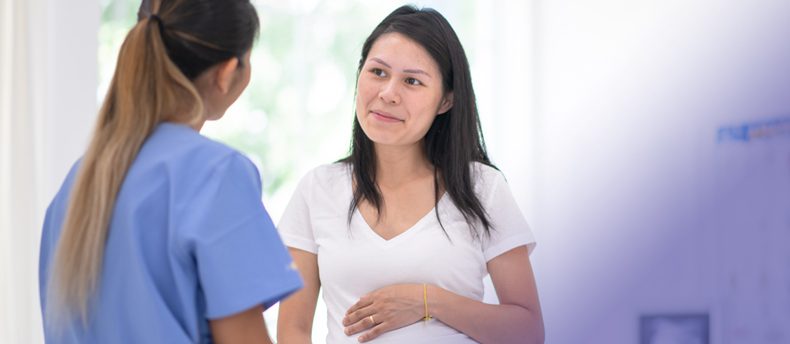 Nurse interacting with patient in hospital room.